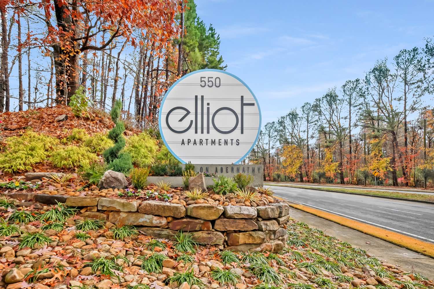 Exterior view of elliot apartments signage and colorful leaves on trees