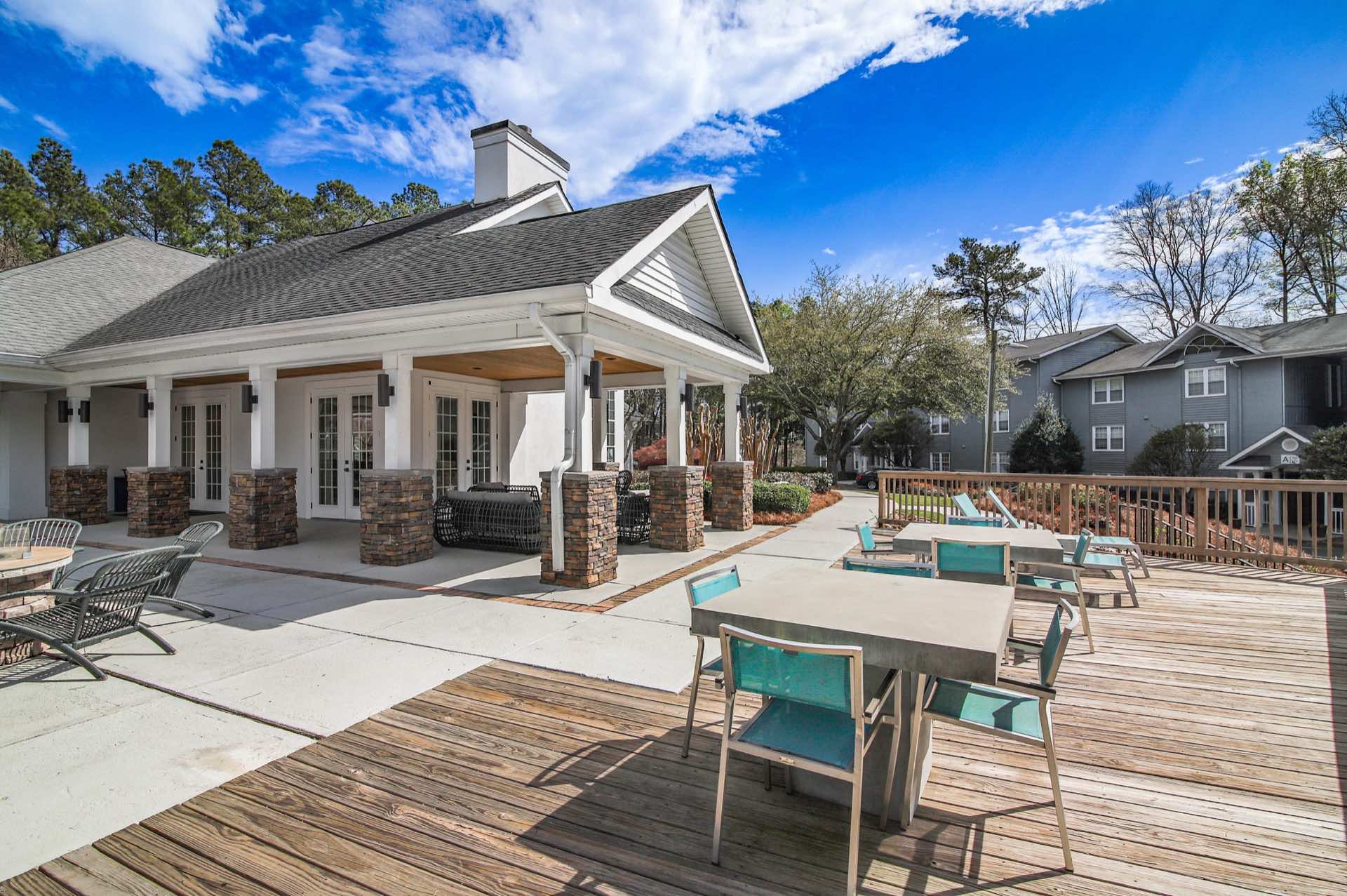 wood deck with table seating, firepit, and covered leasing office patio