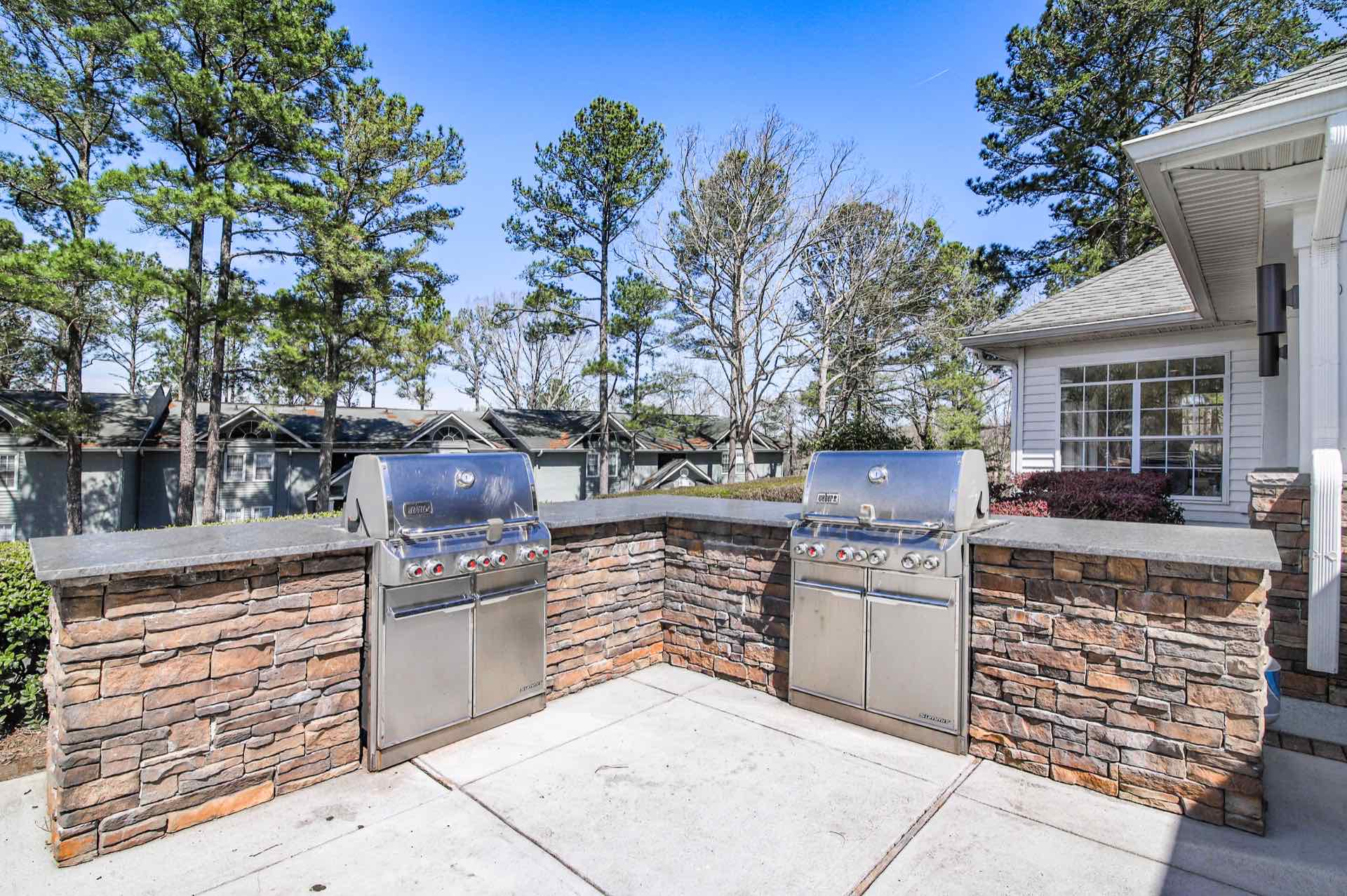 outdoor grill area with built-in gas grills and granite countertops